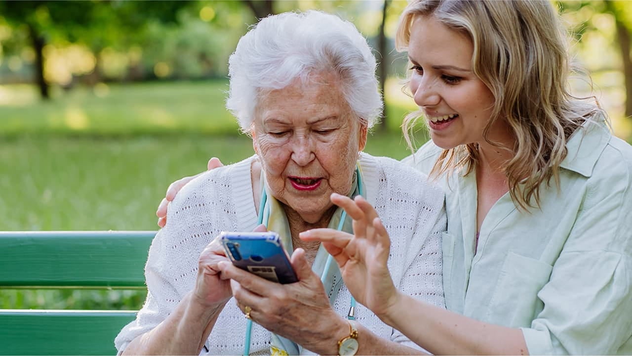 senior woman and daughter with phone in hand