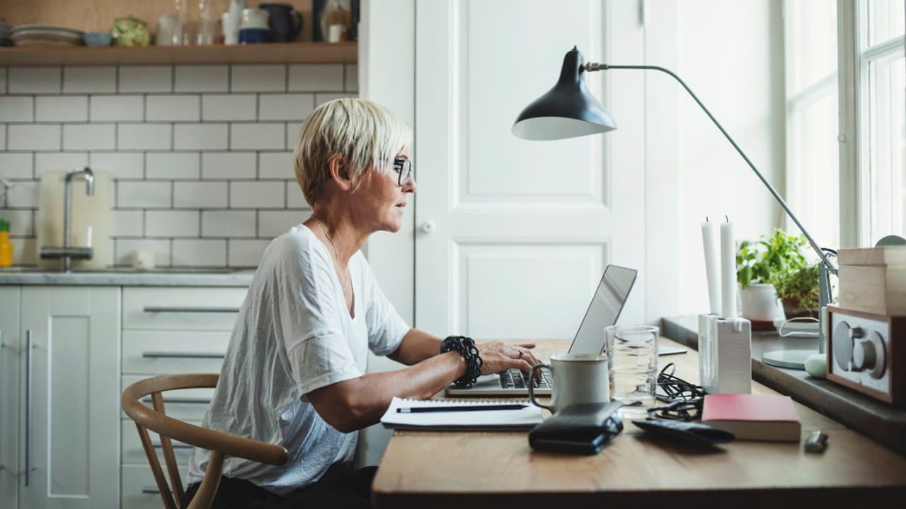 woman working on laptop at kitchen table