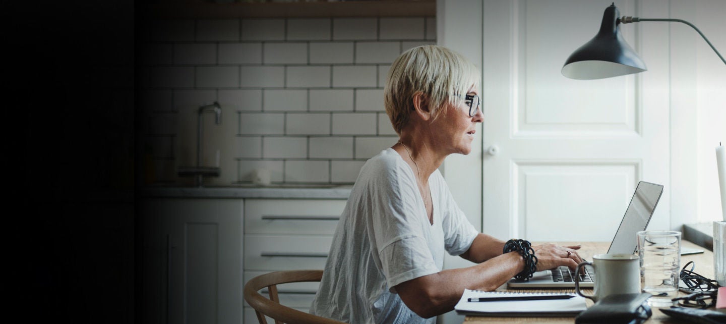 woman working on laptop at kitchen table