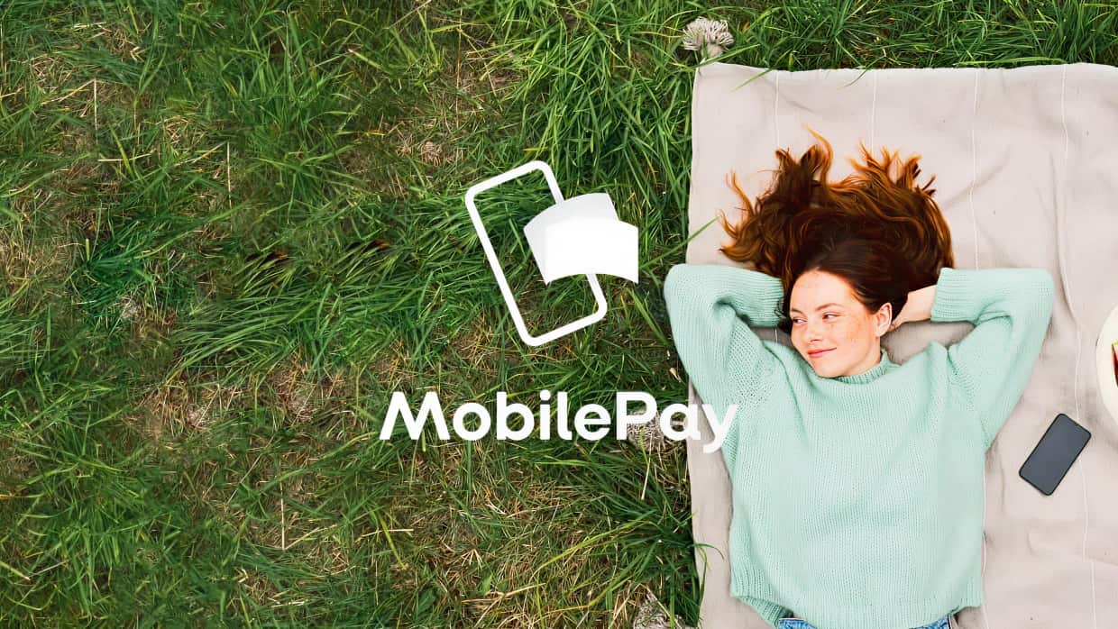 girl lying on grass with mobilepay
